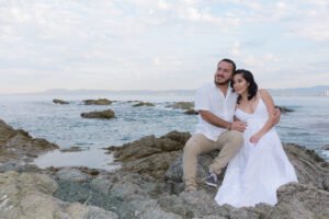 Pareja abrazada en una playa rocosa