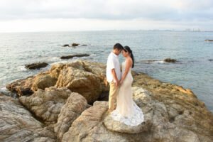Pareja abrazada en una playa rocosa