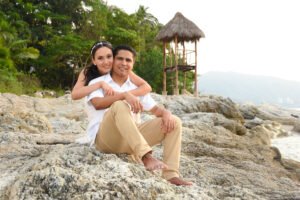 Pareja sentada sobre rocas junto al mar