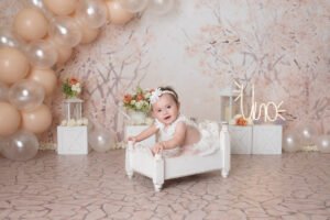 Retrato infantil con globos claros y un pequeño sillón