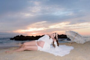 Sesión de embarazo junto al mar con vestido rosa