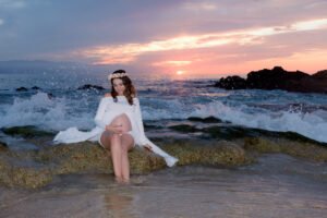 Sesión de embarazo junto al mar con vestido rosa