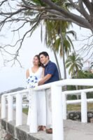 Pareja abrazada junto a una barandilla blanca