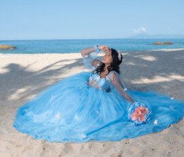 Quinceañera con vestido azul claro en la playa