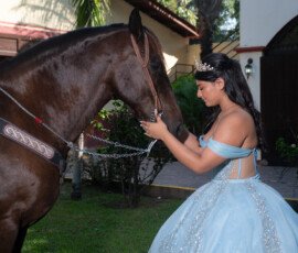 Quinceañera acariciando un caballo