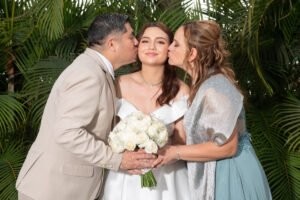 Novios besando a una niña durante la boda