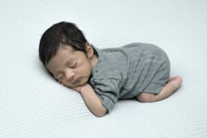 Bebé recién nacido dormido con ropa gris