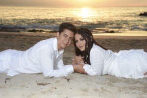Pareja recostada en la arena al atardecer