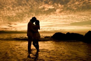 Silueta de una pareja abrazada al atardecer junto al mar
