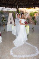 Novios con un ramo junto a letras decorativas