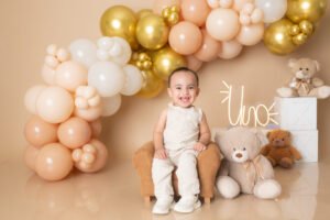 Retrato infantil con globos dorados y osos de peluche